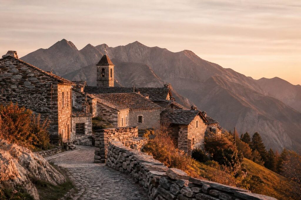 Village de montagne au crépuscule avec un clocher et des maisons en pierre