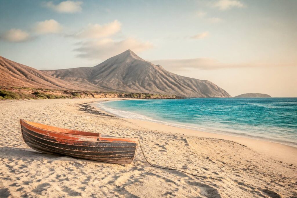 Plage dorée du Cap Vert avec barque colorée et eau turquoise