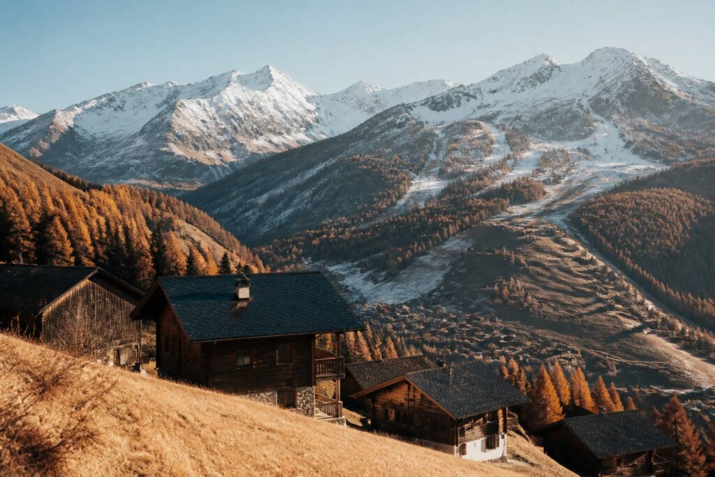 Village de montagne alpin avec chalets et sommets enneigés